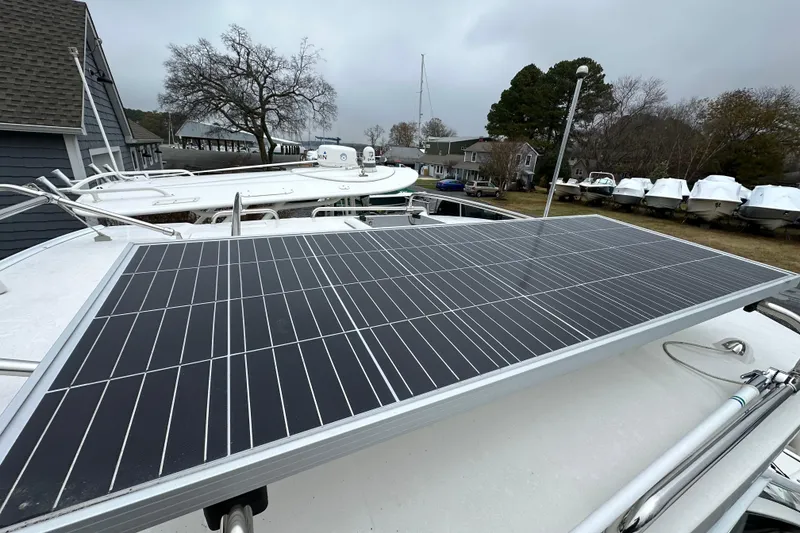 Slide: The Image of 2022 Cutwater C-24 DC boat with solar panel on deck, docked near other boats. - 17