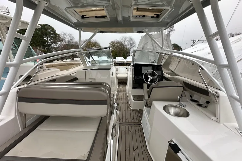 Slide: The Image of 2022 Cutwater C-24 DC boat interior with seating, helm, and sink. - 6