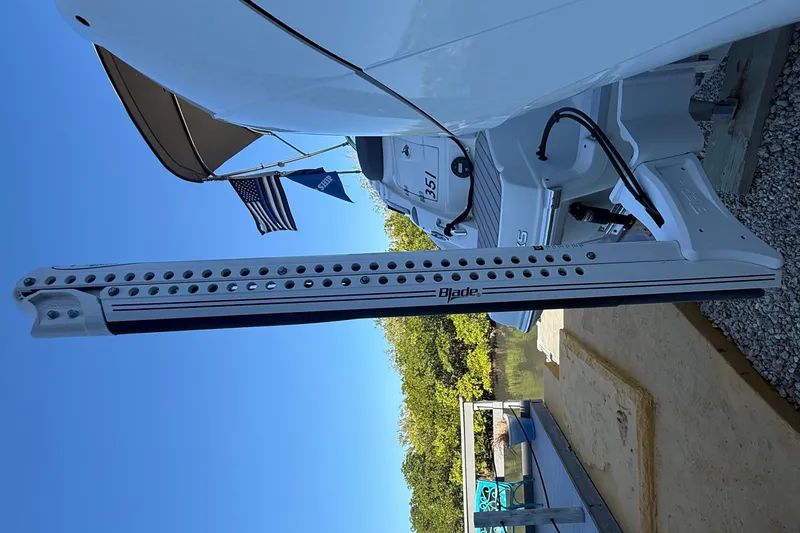 Slide: The Image of 2022 Crownline Eclipse E235 XS boat with Blade power pole, docked under clear sky. - 11