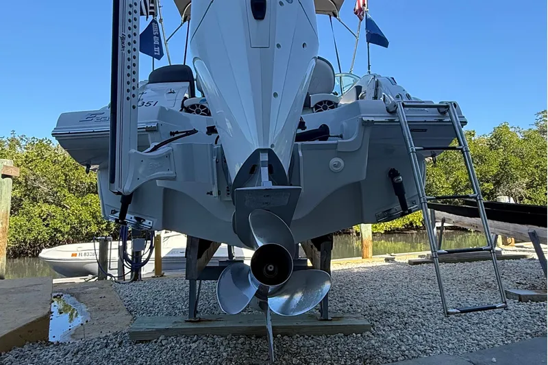 Slide: The Image of 2022 Crownline Eclipse E235 XS boat on dry dock with visible propeller and ladder. - 17