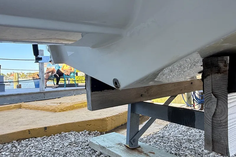 Slide: The Image of 2022 Crownline Eclipse E235 XS boat hull on a wooden support near a waterfront. - 21