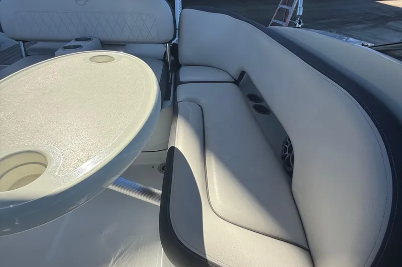 Slide: The Image of 2022 Crownline Eclipse E235 XS boat interior with cushioned seating and table. - 33