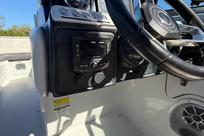 Slide: The Image of 2022 Crownline Eclipse E235 XS dashboard with steering wheel and audio controls. - 44