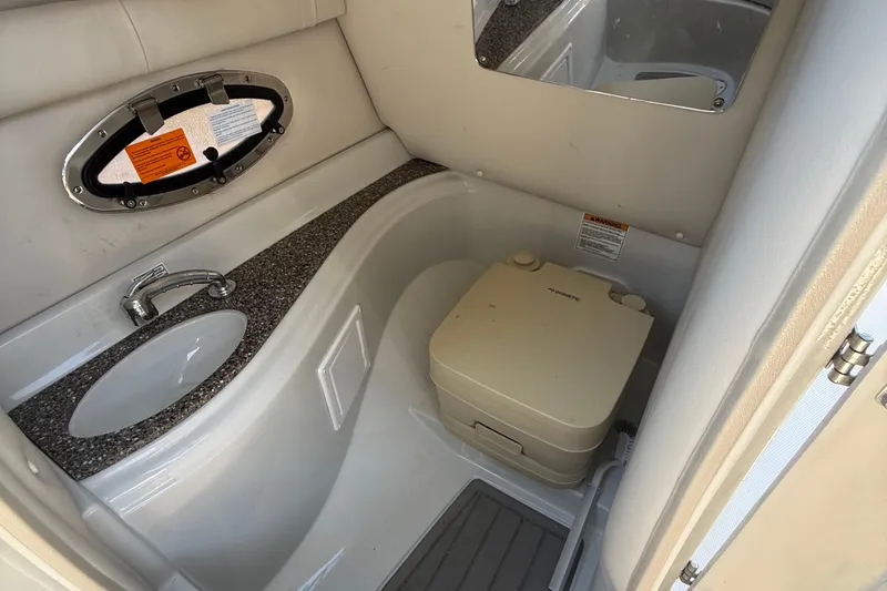 Slide: The Image of 2022 Crownline Eclipse E235 XS boat interior with sink and portable toilet. - 49