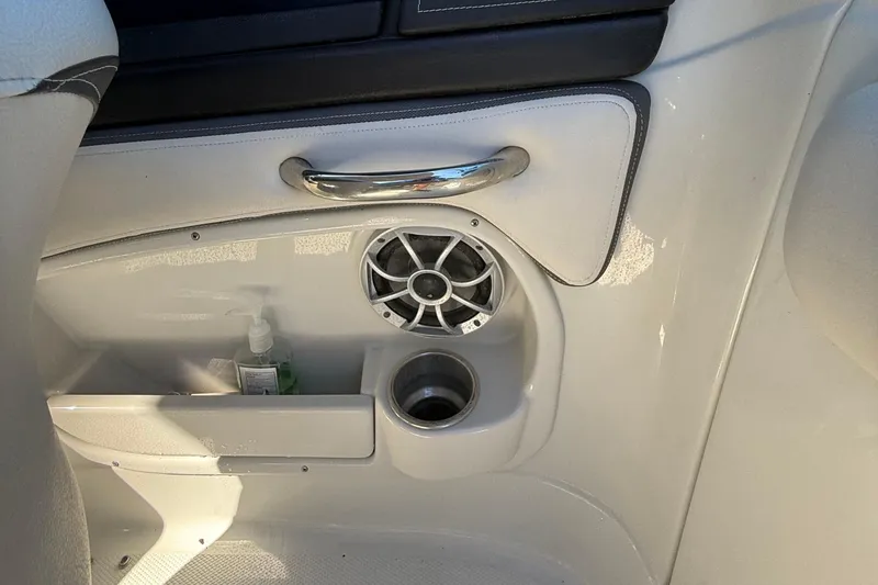 Slide: The Image of 2022 Crownline Eclipse E235 XS interior with speaker, cup holder, and storage compartment. - 54