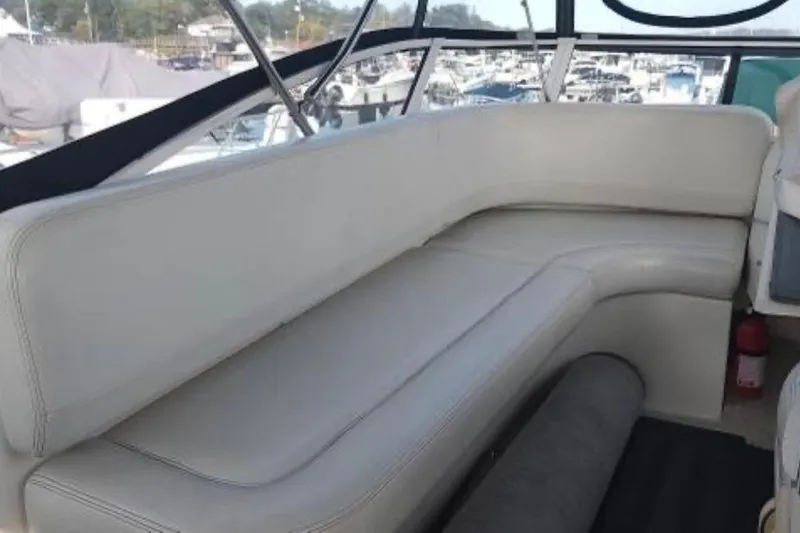 Slide: The Image of 2001 Silverton 330 Sport Bridge interior with white leather seating and marina view. - 4
