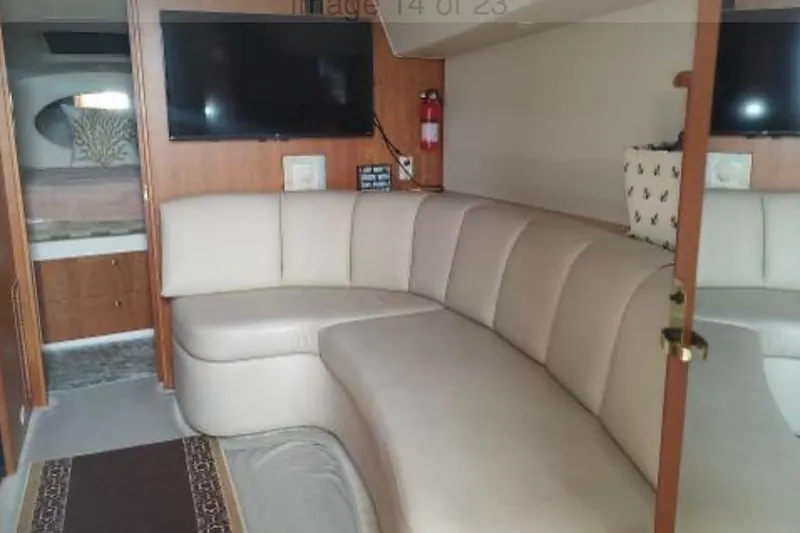 Slide: The Image of Interior of 2001 Silverton 330 Sport Bridge with beige seating and wall-mounted TV. - 5