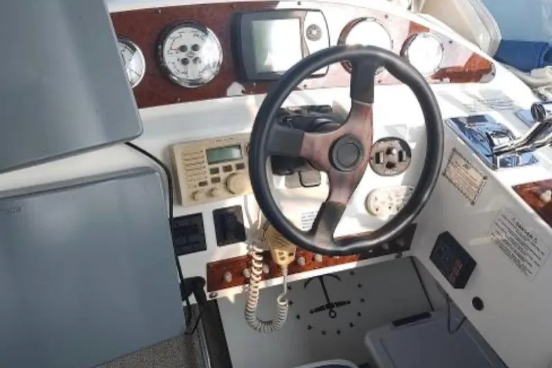 Slide: The Image of 2001 Silverton 330 Sport Bridge helm with steering wheel and navigation instruments. - 7