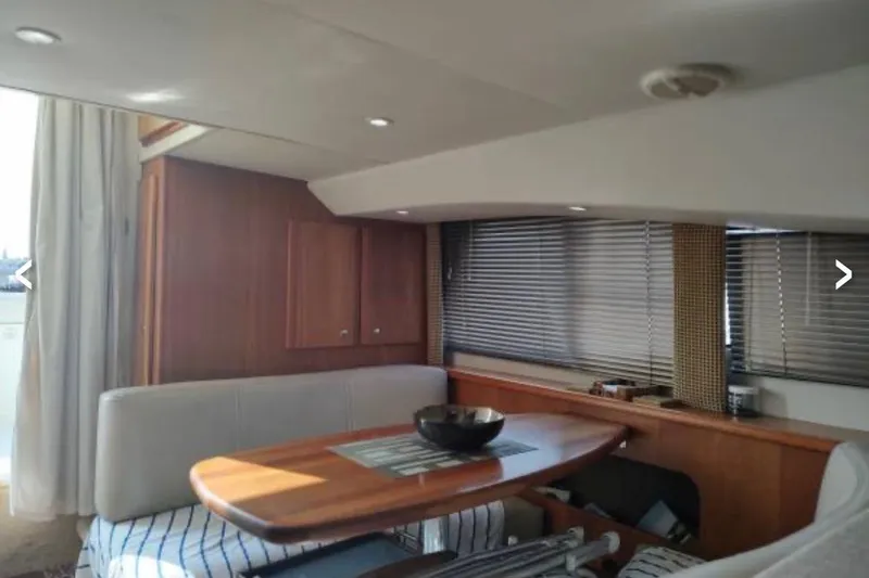 Slide: The Image of Interior of 2001 Silverton 330 Sport Bridge yacht with dining area and wooden accents. - 8