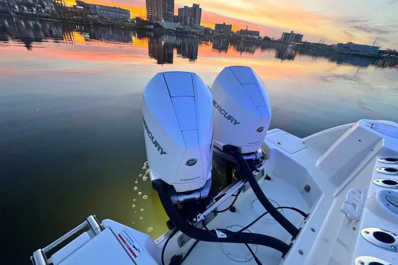 Slide: The Image of 2025 Sailfish 276 DC boat with dual Mercury engines at sunset on calm water. - 4