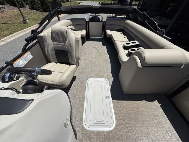 Slide: The Image of 2021 Barletta Boats C24Q interior with beige seating and steering console. - 6