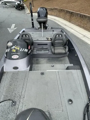 Slide: The Image of 2008 Bee Line Super Vee boat with dual seats and motor, parked on a street. - 14