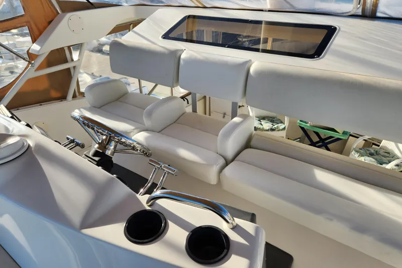 Slide: The Image of 2001 Silverton 392 Motor Yacht helm with white seating and steering wheel. - 11