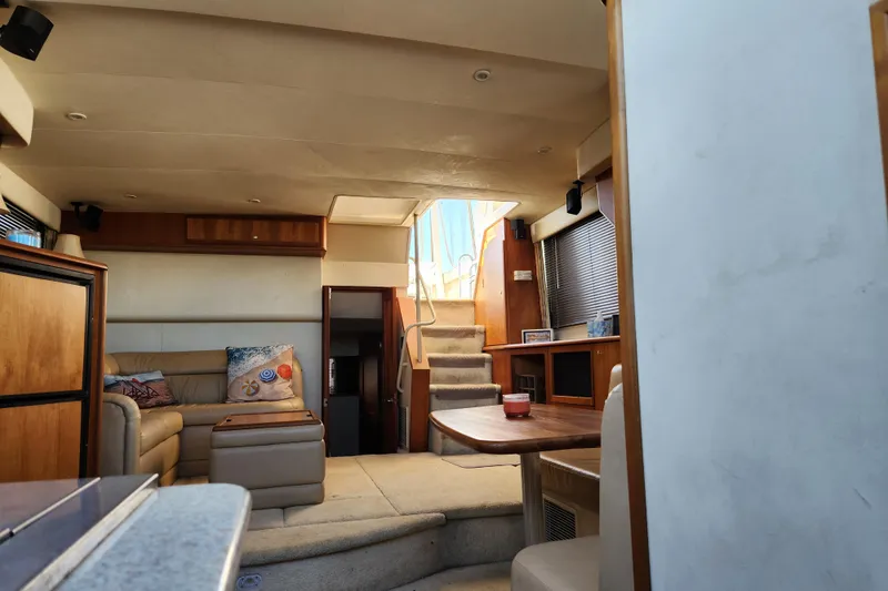 Slide: The Image of Interior of 2001 Silverton 392 Motor Yacht with cozy seating and wooden accents. - 29