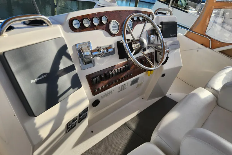 Slide: The Image of 2001 Silverton 392 Motor Yacht helm with steering wheel and Raymarine navigation system. - 7