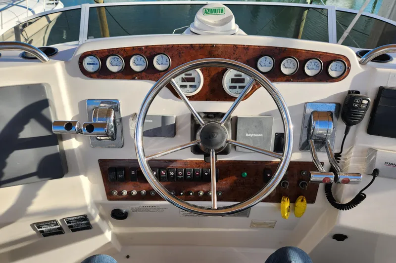 Slide: The Image of 2001 Silverton 392 Motor Yacht helm with steering wheel, gauges, and controls. - 8