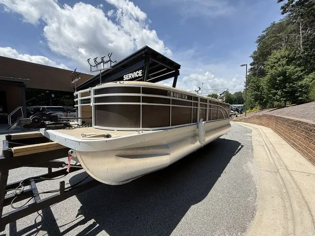 Slide: The Image of 2016 Bennington 22 SSX pontoon boat parked outside a service center under a clear sky. - 5