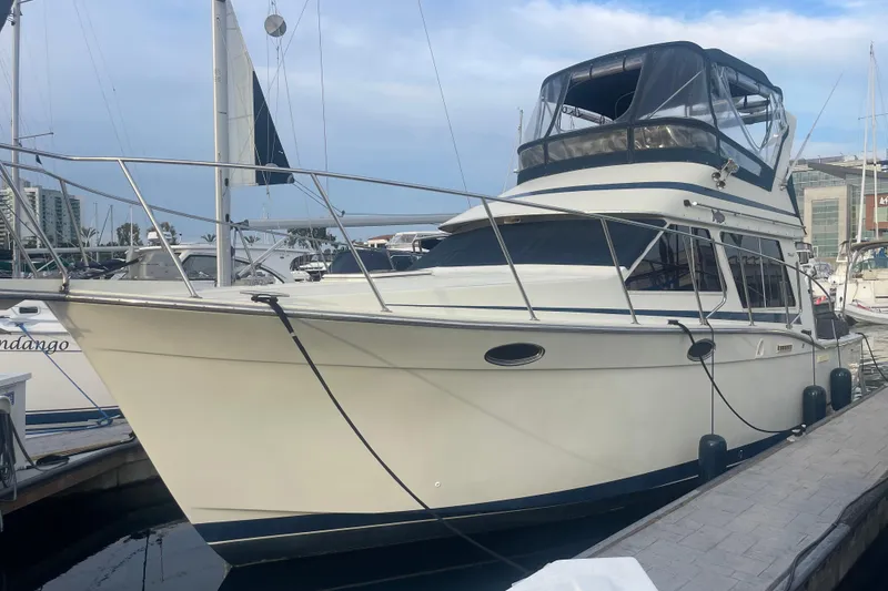 The Image of 1988 Tollycraft 34 Convertible Sedan docked at marina, featuring sleek design and spacious cabin. - 0