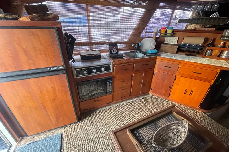 Slide: The Image of 1988 Tollycraft 34 Convertible Sedan kitchen with wooden cabinets and appliances. - 14