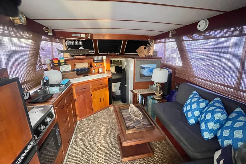 Slide: The Image of Interior of 1988 Tollycraft 34 Convertible Sedan with cozy seating and wooden cabinetry. - 15
