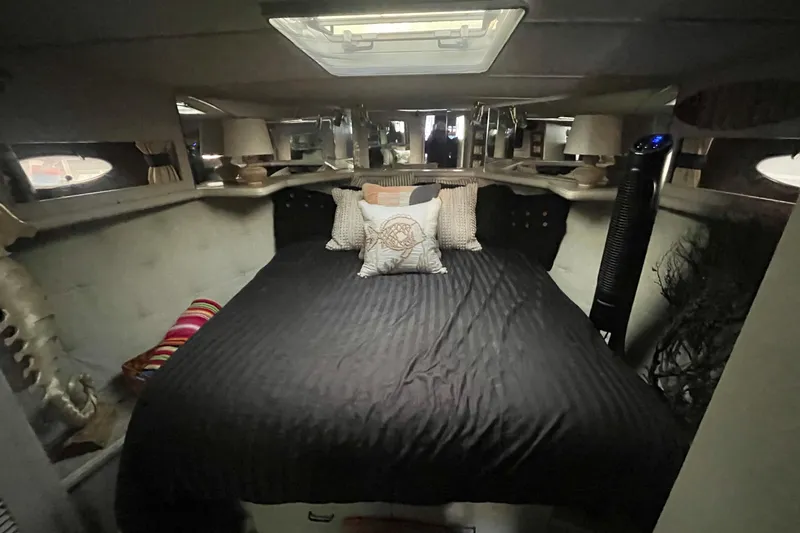 Slide: The Image of 1988 Tollycraft 34 Convertible Sedan cabin with cozy bed and decorative pillows. - 17