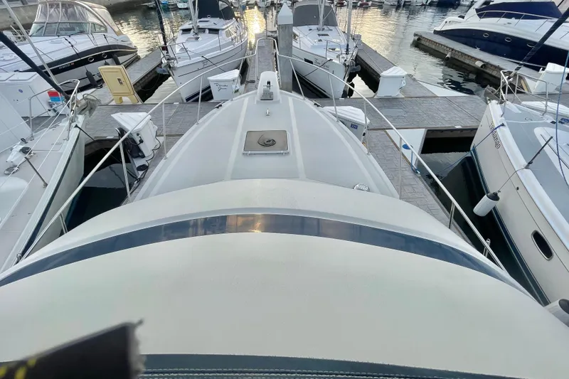 Slide: The Image of 1988 Tollycraft 34 Convertible Sedan docked among other boats at a marina. - 2