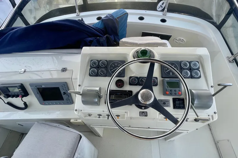Slide: The Image of 1988 Tollycraft 34 Convertible Sedan helm with steering wheel and navigation instruments. - 3