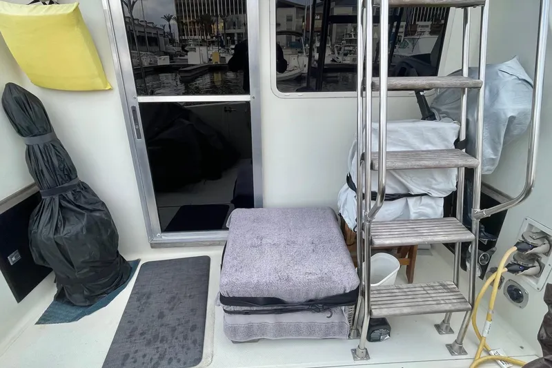 Slide: The Image of 1988 Tollycraft 34 Convertible Sedan boat interior with ladder and covered equipment. - 7