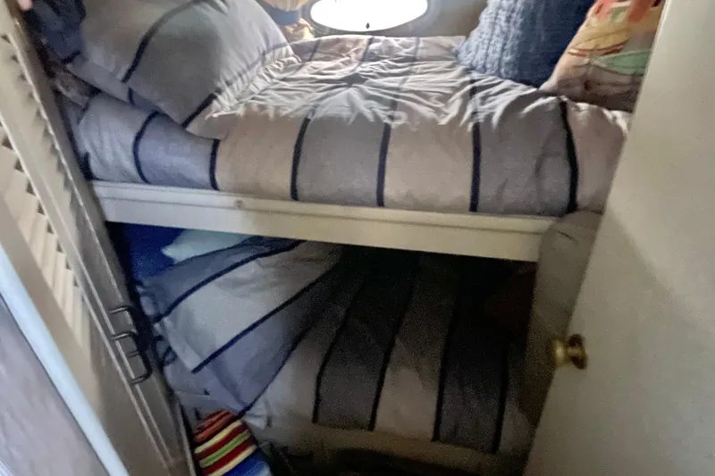 Slide: The Image of Bunk beds in 1988 Tollycraft 34 Convertible Sedan cabin, with striped bedding. - 8