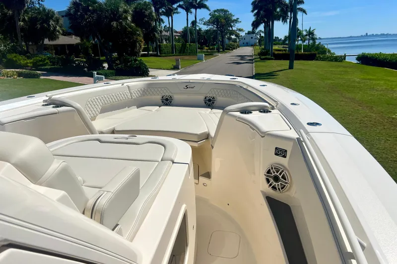 Slide: The Image of 2026 Scout 357 LXF boat with luxurious seating and scenic waterfront view. - 10