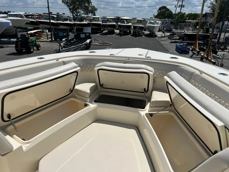 Slide: The Image of 2025 Scout 357 LXF boat with open storage compartments, docked in a marina. - 11