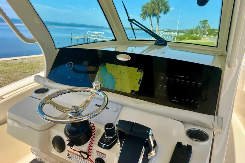 Slide: The Image of 2026 Scout 357 LXF boat dashboard with navigation screens and steering wheel. - 15