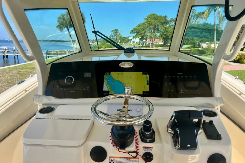 Slide: The Image of 2026 Scout 357 LXF boat dashboard with navigation screens and steering wheel. - 16