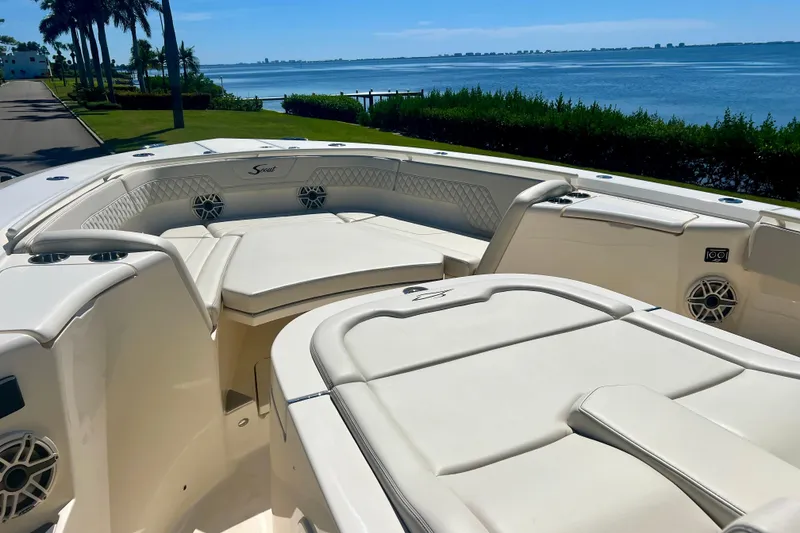 Slide: The Image of 2026 Scout 357 LXF boat with luxurious seating, overlooking a scenic waterfront. - 6