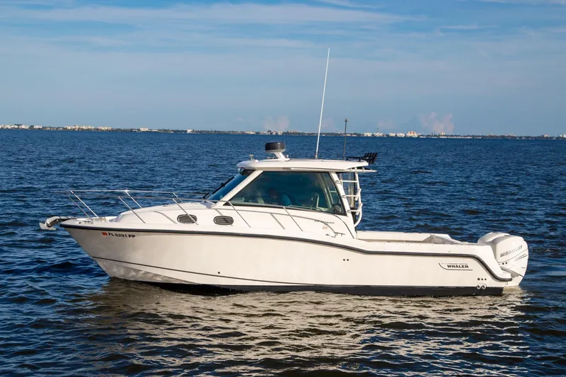 The Image of 2014 Boston Whaler 315 Conquest boat cruising on open water. - 0