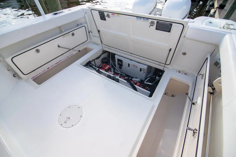 Slide: The Image of 2014 Boston Whaler 315 Conquest boat with open storage compartments and visible engine components. - 17