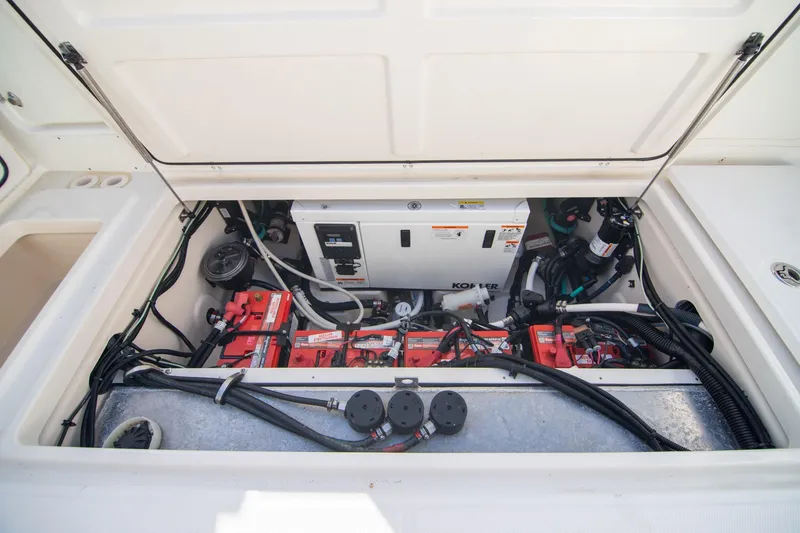Slide: The Image of 2014 Boston Whaler 315 Conquest engine compartment with batteries and wiring. - 18