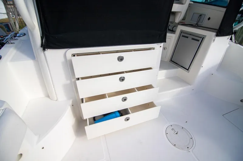 Slide: The Image of 2014 Boston Whaler 315 Conquest boat interior with open storage drawers. - 21