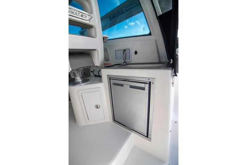 Slide: The Image of 2014 Boston Whaler 315 Conquest interior with compact refrigerator and storage. - 22