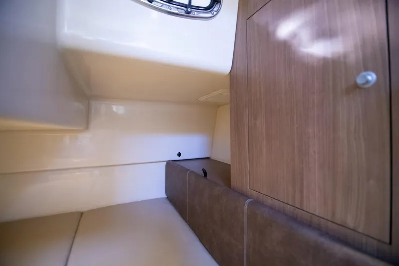 Slide: The Image of 2014 Boston Whaler 315 Conquest cabin interior with wood cabinetry and seating. - 34