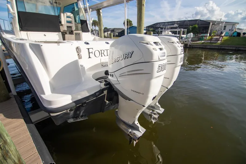Slide: The Image of 2014 Boston Whaler 315 Conquest with twin Mercury 300 engines docked by water. - 38