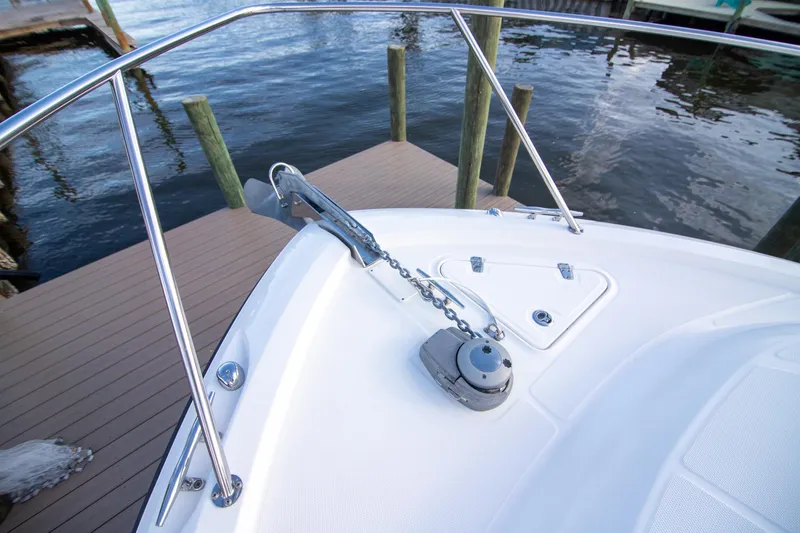Slide: The Image of 2014 Boston Whaler 315 Conquest bow with anchor and railing, docked by water. - 6