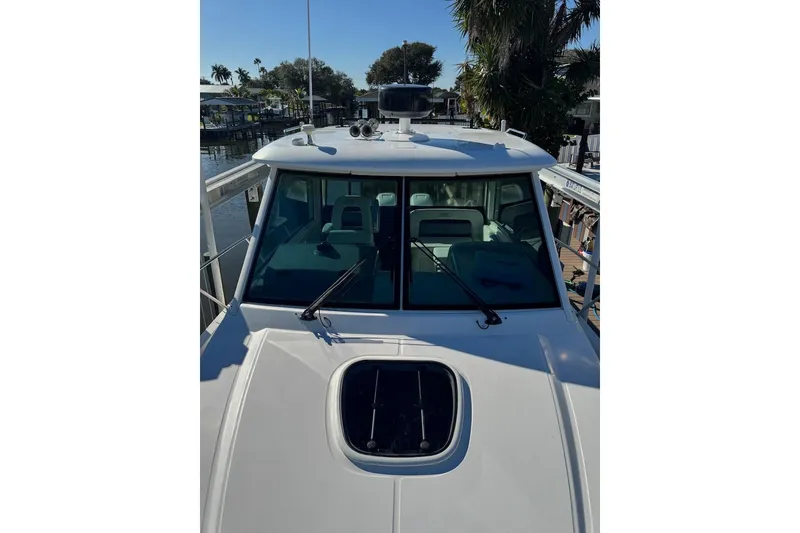 Slide: The Image of 2014 Boston Whaler 315 Conquest boat docked near palm trees. - 8