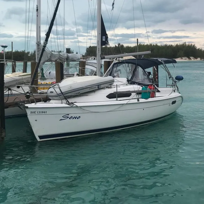 The Image of 2003 Hunter 306 sailboat docked in clear turquoise water, overcast sky. - 0