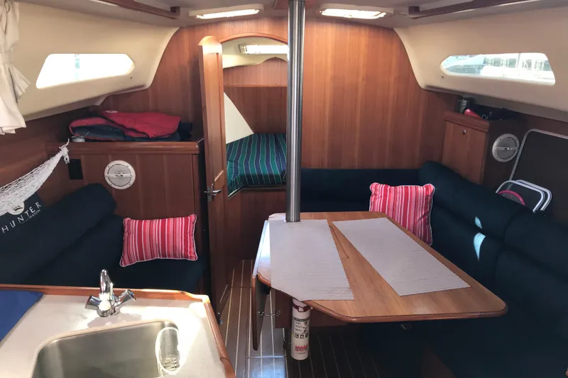 Slide: The Image of Cozy interior of 2003 Hunter 306 sailboat with wood finish and seating area. - 5