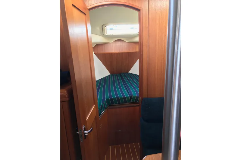 Slide: The Image of Cozy cabin interior of 2003 Hunter 306 sailboat with striped bedding. - 6