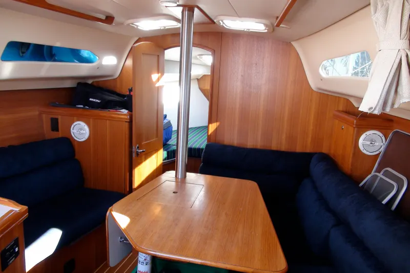 Slide: The Image of Interior of 2003 Hunter 306 sailboat with wooden furnishings and blue seating. - 7