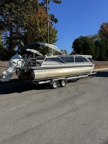 Slide: The Image of 2022 Godfrey Pontoons Monaco 235 on trailer, parked on a road with trees in the background. - 8