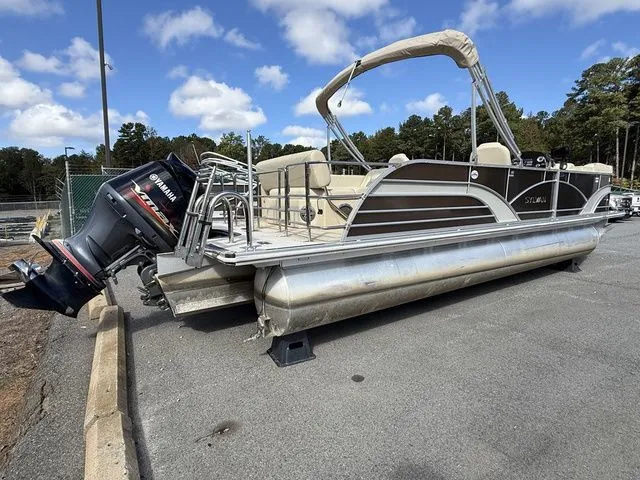 Slide: The Image of 2017 Sylvan 8524 DLZ LE pontoon boat with Yamaha outboard motor, parked on pavement. - 3