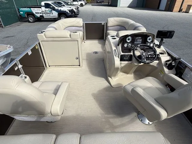 Slide: The Image of 2017 Sylvan 8524 DLZ LE pontoon boat interior with beige seating and modern dashboard. - 6